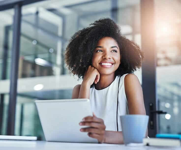 smiling woman sitting in front of her laptop