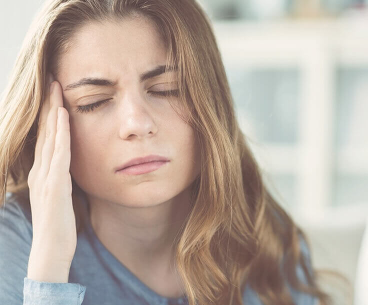 woman holding her jaw in pain